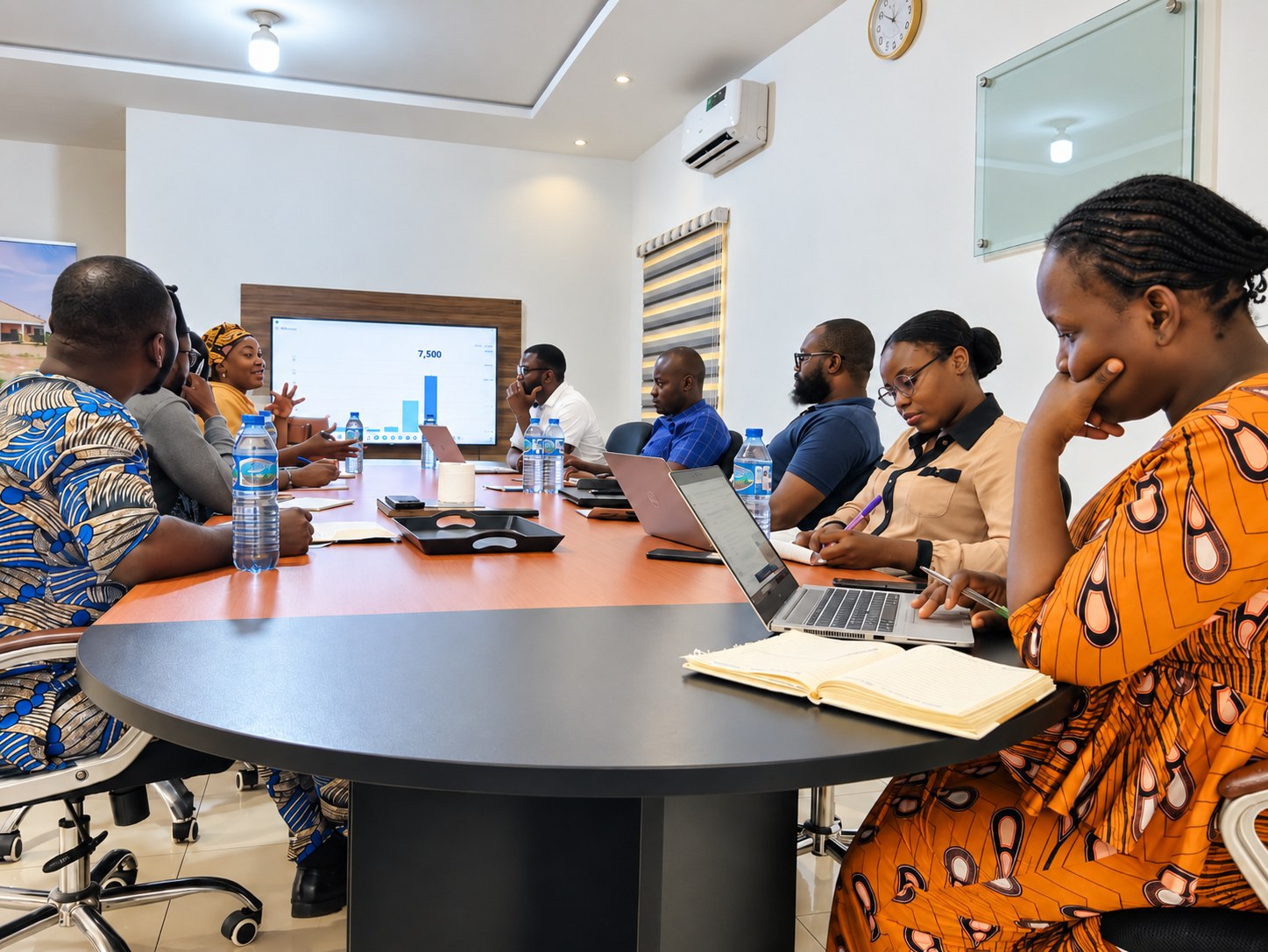 Team reviewing programme figures on a boardroom screen